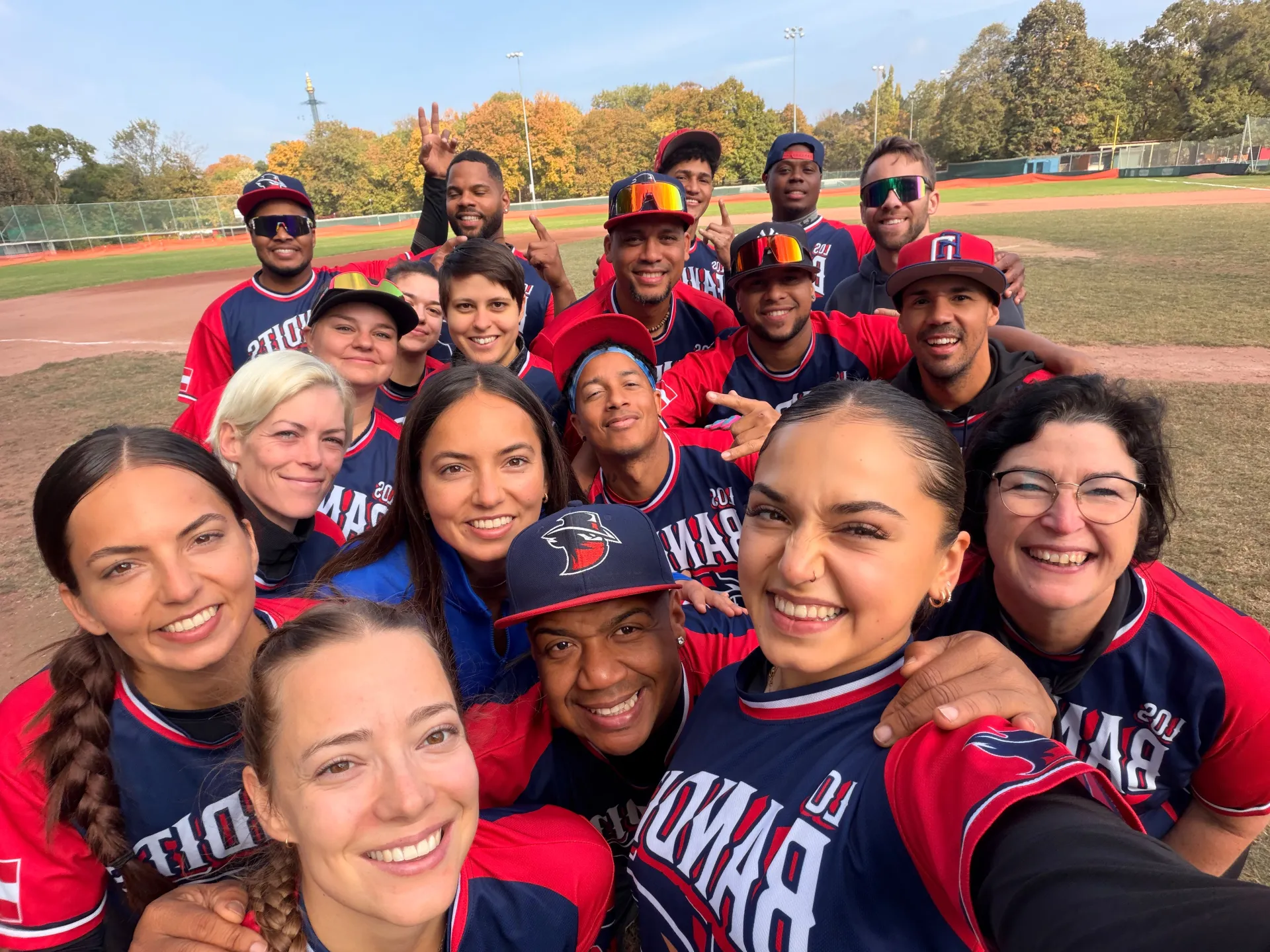 Gut gelauntes Selfie des Teams in Trikots auf dem Spielfeld bei Herbstsonne
